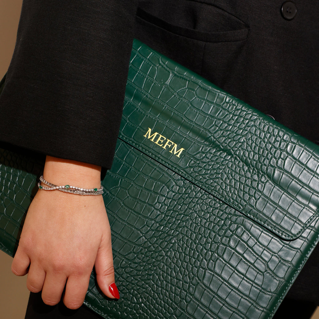 Close-up of styled accessories and monogrammed portfolio during a brand photo shoot